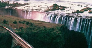 Aerial view of Victoria Falls with train on the bridge in the foreground